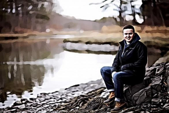 Man Wearing Black Jacket Sitting on Gray Stone Near River