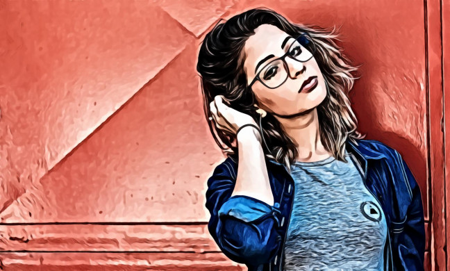 Woman Holding Her Hair Leaning on Red Wall