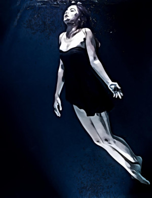 Woman Wearing Short Black Dress Swimming Underwater