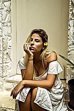 Woman in white dress sitting near closed door