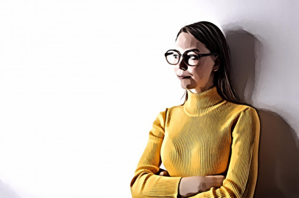Woman Standing Against Wall Wearing Yellow Turtleneck Sweater