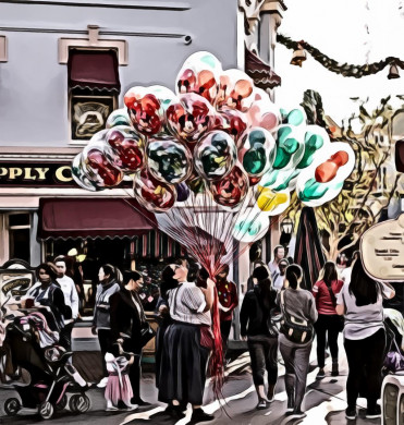 Woman holding balloons surrounded by people at the road