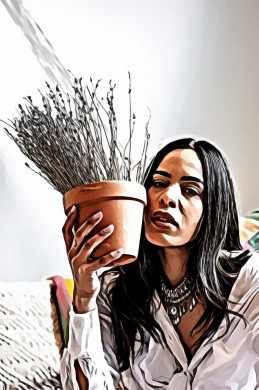 Woman holding potted plant next to her face