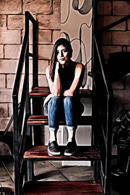 Woman in blue denim jeans sitting on brown stair