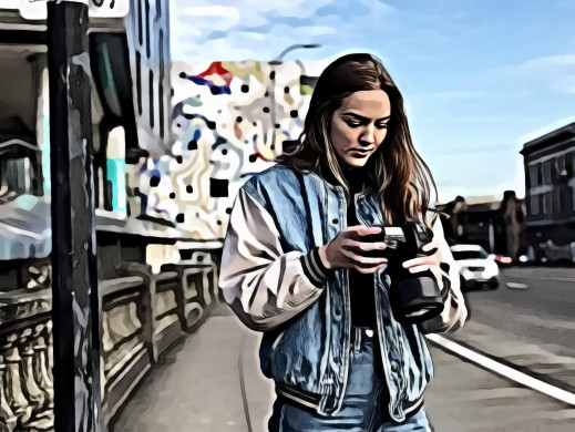 Woman wearing denim jacket holding black dslr camera