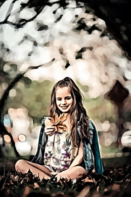 Smiling girl sitting on ground holding out dry maple leaf