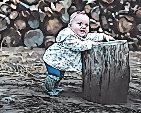 Toddler standing and leaning against log