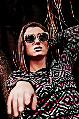 Woman wearing multicolored tribal sweater and sunglasses standing and about to raise her right hand