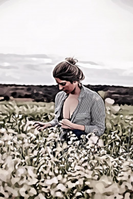 Woman with opened cleavage knelling in the middle of grass field
