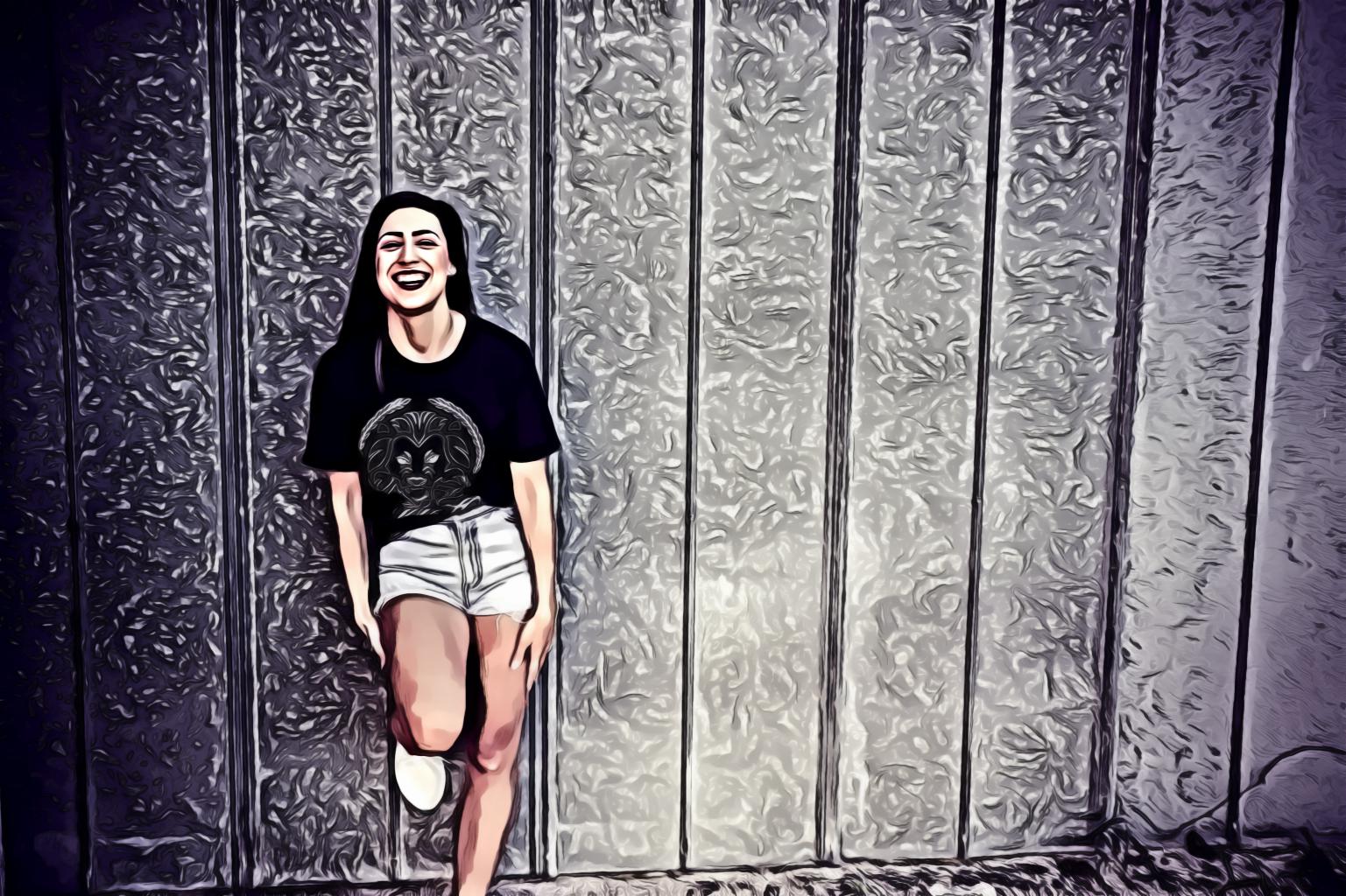 Woman Wearing Black and White Crew-neck T-shirt and Gray Denim Short Shorts Outfit Leaning on Gray Wall