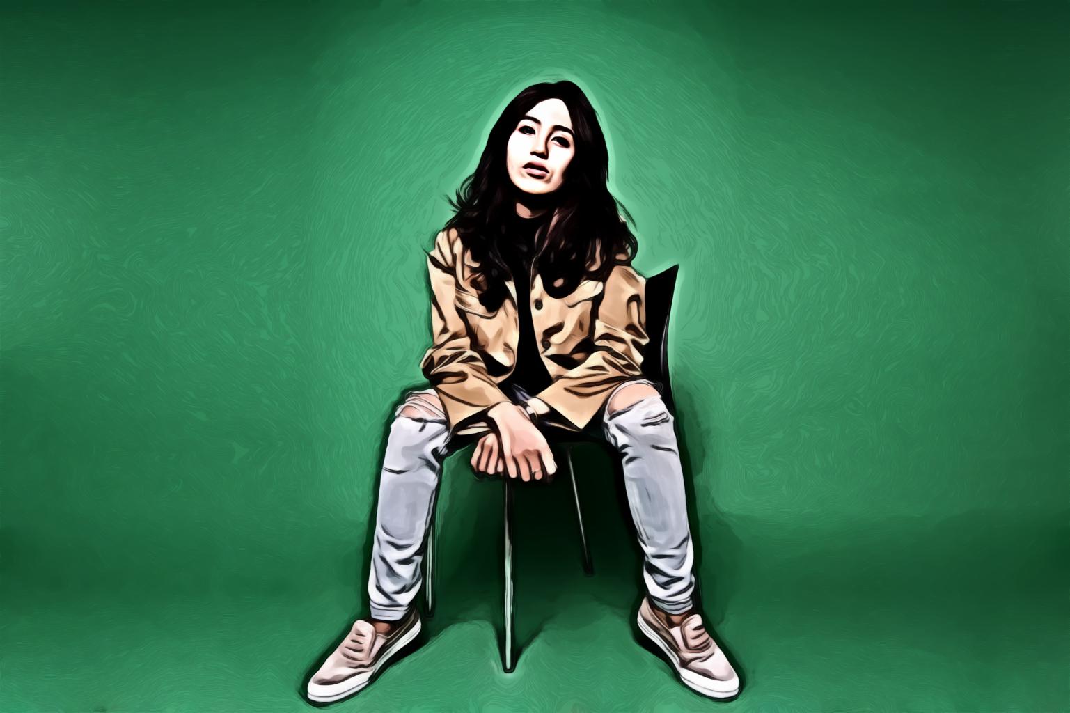 Woman Sitting On Black Chair With Green Background