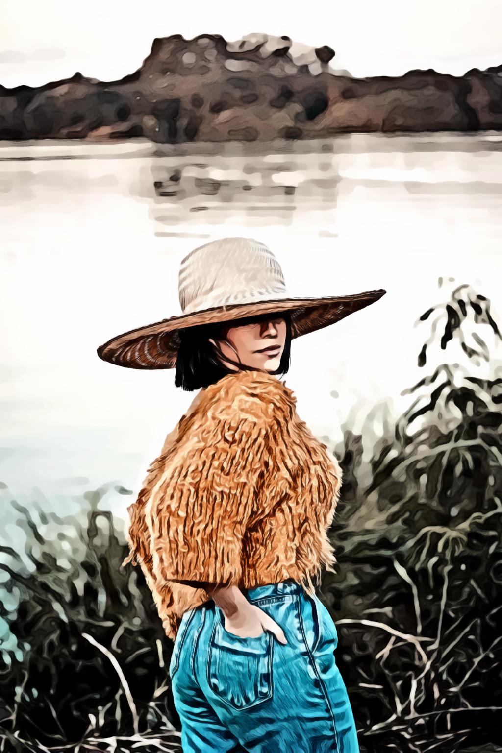 Woman in sun hat orange knitted top and blue denim bottoms